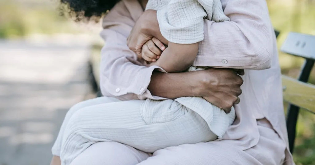 Parent qui prend son enfant dans les bras, moment de calme